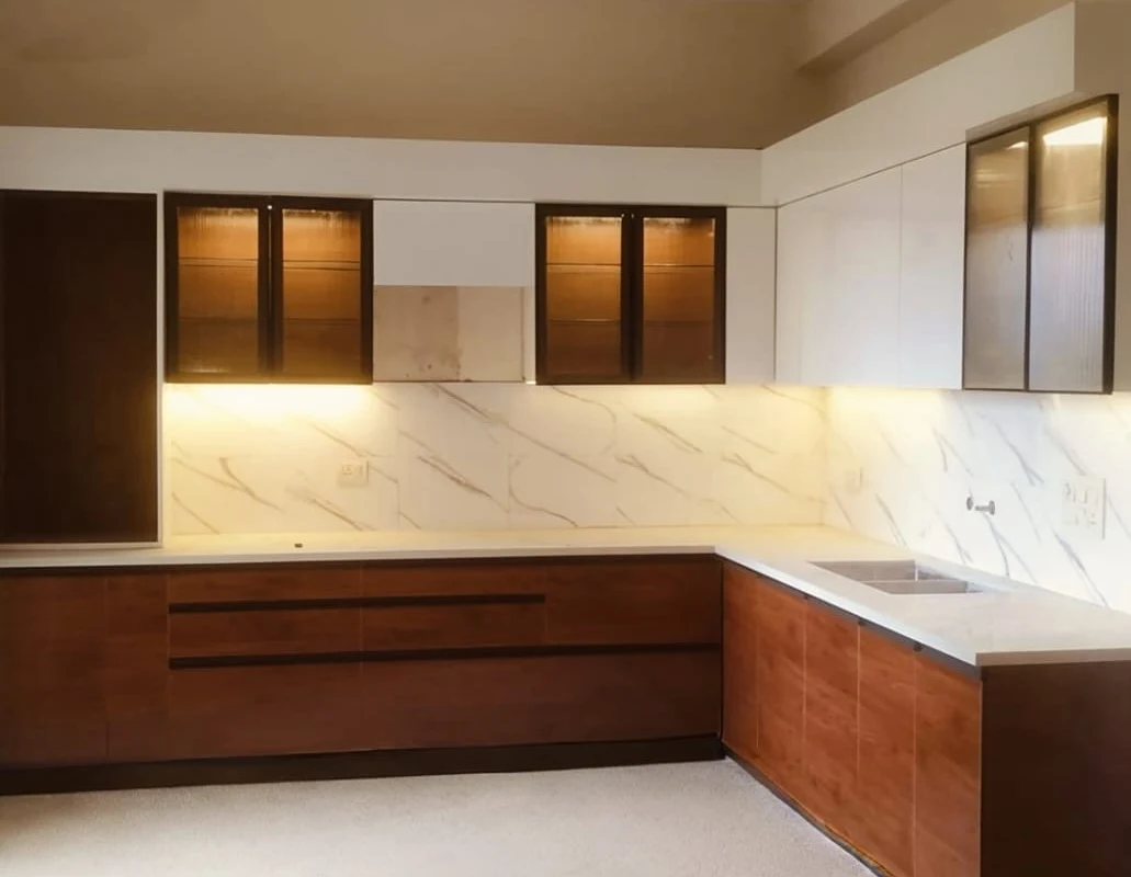 Dark wood-finish modular kitchen by Livibi with a white marble countertop, backsplash and lit glass-front upper cabinets
