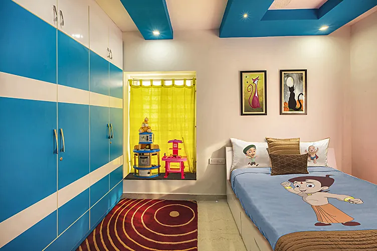 Kids' bedroom with a blue high-gloss wardrobe wall, red and gold medallion rug, single bed with a Chhota Bheem bedsheet