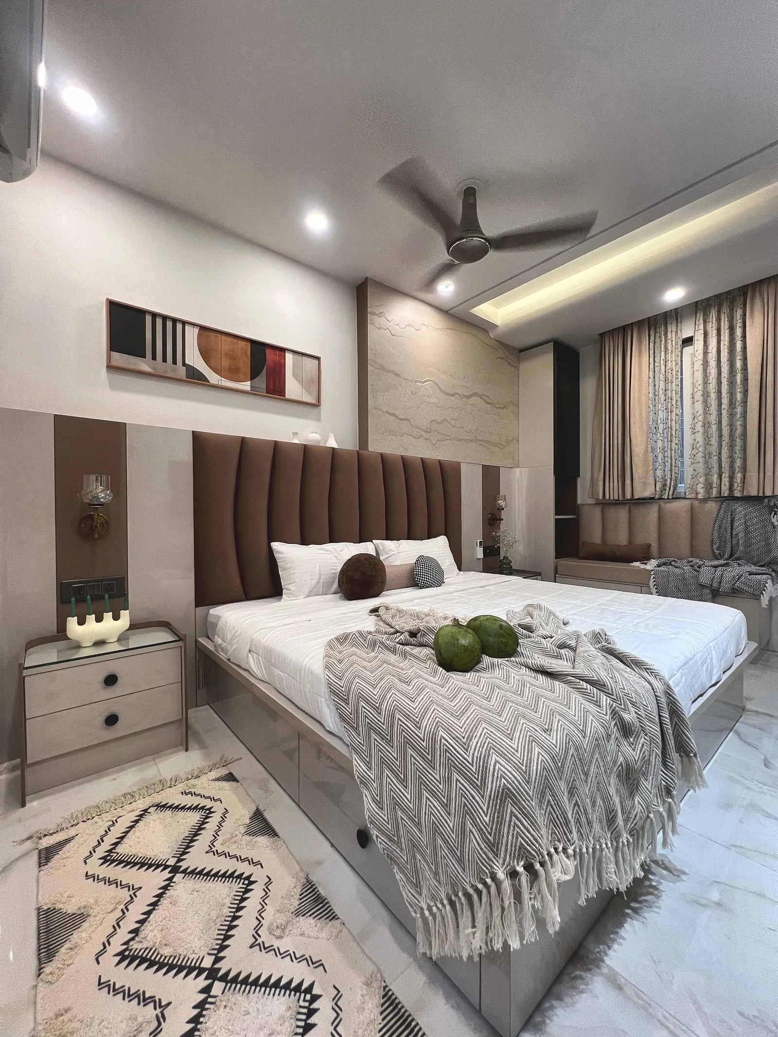 Warm-neutral master bedroom with a brown channel-tufted headboard against a stone-textured panel