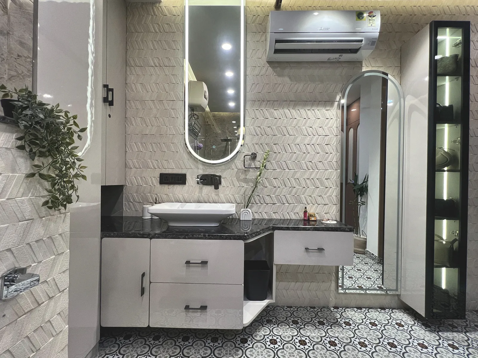 Bathroom interior by Livibi with a black-granite vanity counter, arched full-length mirror and wall-mounted split AC unit