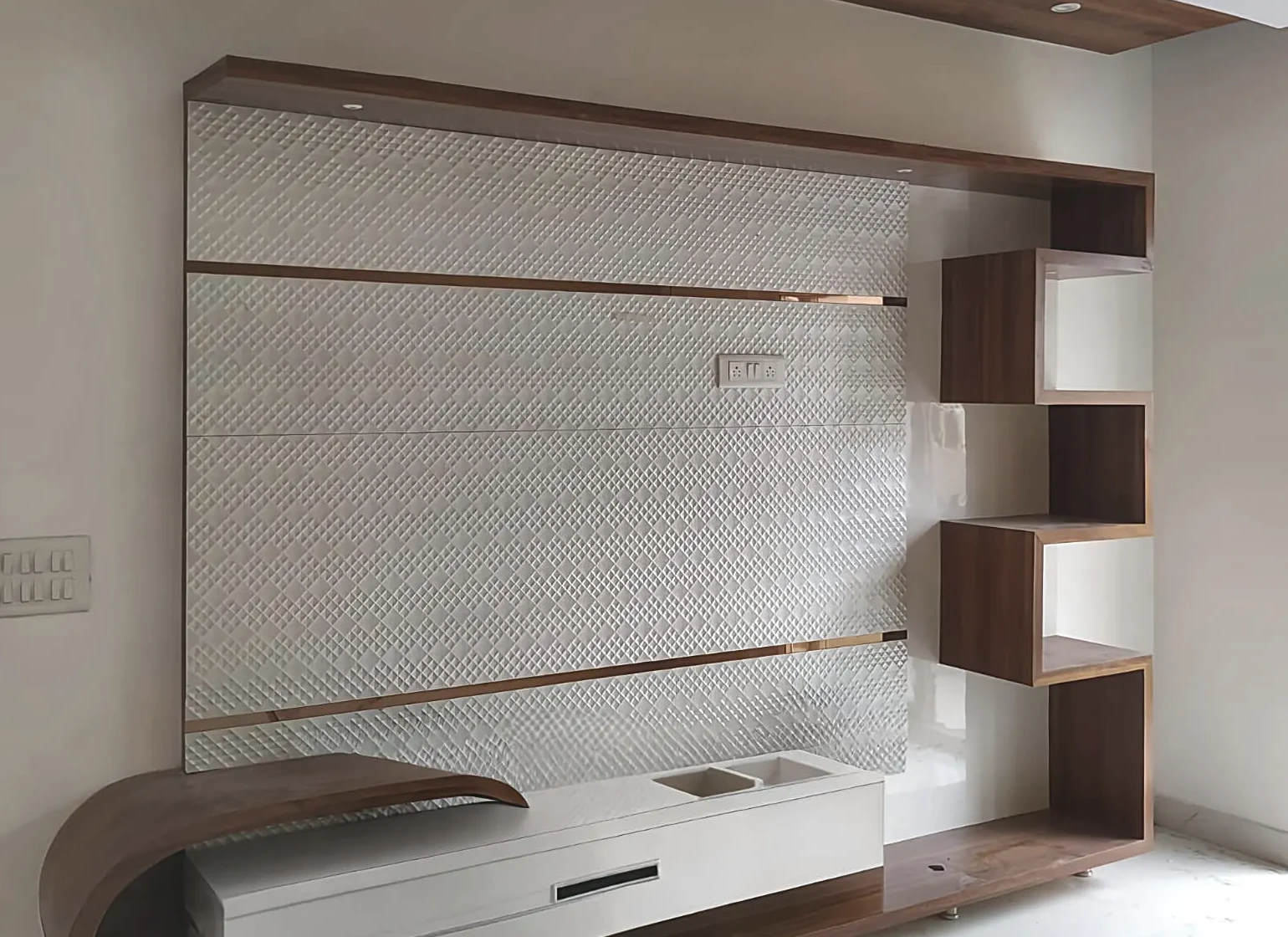 Living room TV wall by Livibi with a quilted-texture panel and a sculptural curved console